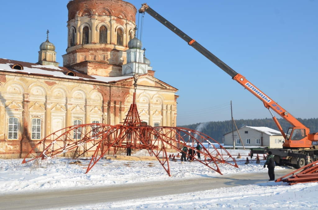 Кран поднимает конструкцию над землей для монтажа ребер.